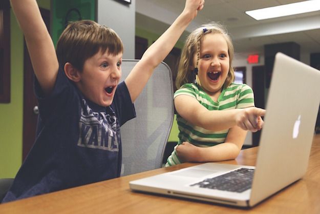 Foto che mostra due bambini che guardano un video da un MacBook