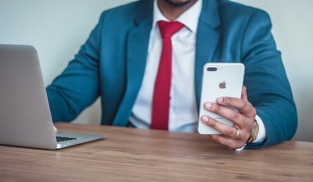 Uomo con MacBook e iPhone