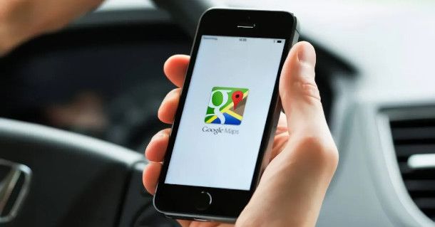 persona in auto che accede a Google Maps da smartphone