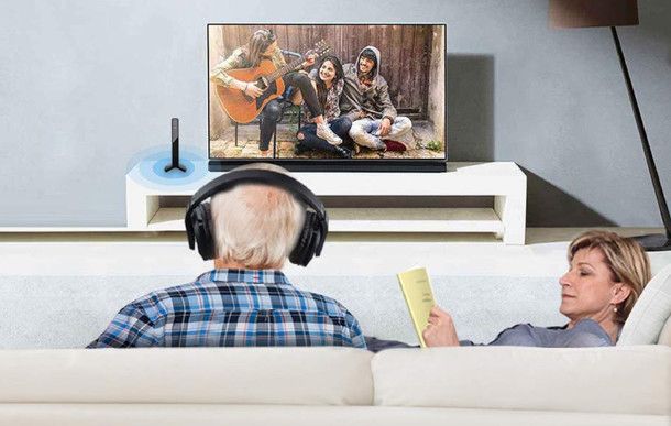 anziano che ascolta l'audio della TV in cuffia