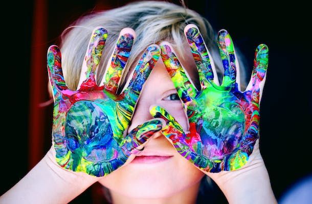 bambino con mani colorate