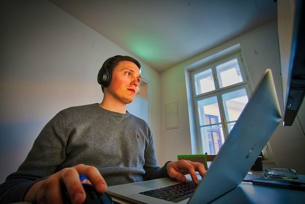 Ragazzo con cuffie e MacBook