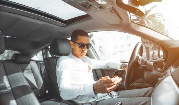 persona che consulta lo smartphone in auto