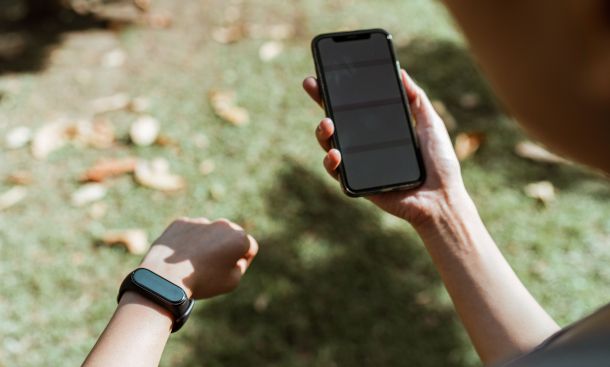 persona con smartband e smartphone