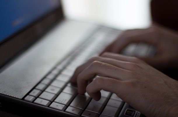 persona che scrive un'email al pc