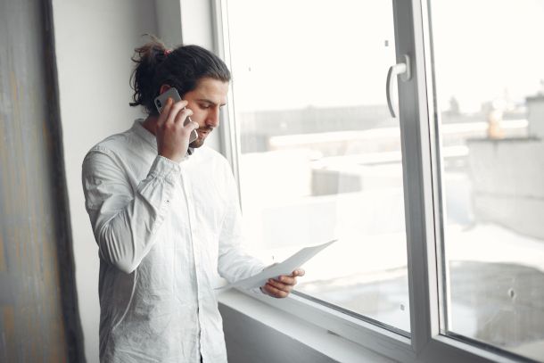 persona al telefono con modulo in mano